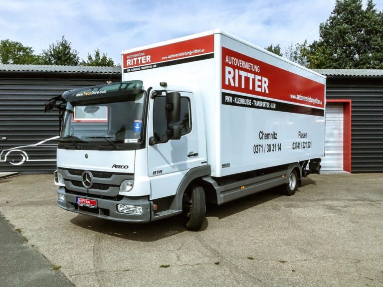Weißer Mercedes LKW der Autovermietung Ritter mit Kofferaufbau vor einem Firmengebäude.