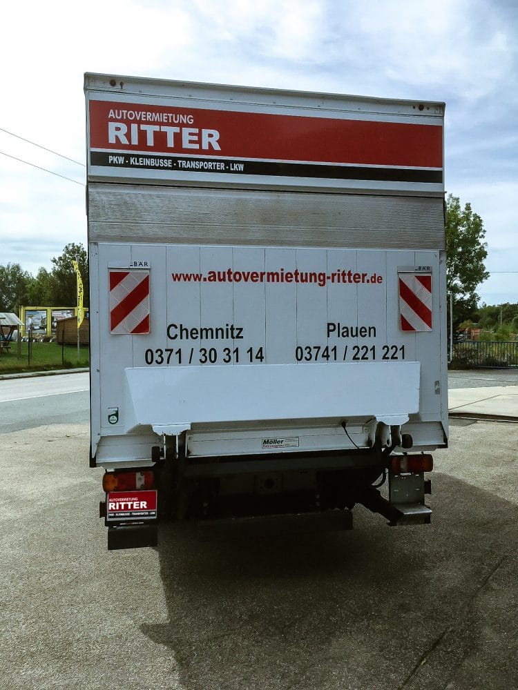 Heckansicht eines weißen LKW der Autovermietung Ritter mit Standortinfos für Chemnitz und Plauen.