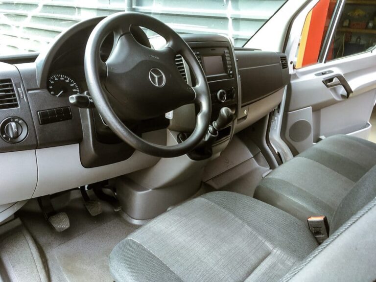 Cockpit eines Mercedes Transporters mit Lenkrad, Armaturenbrett und Sitzbank.