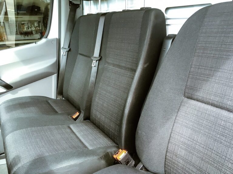 Sitzreihe im Mercedes Transporter mit Sicherheitsgurten und Stoffpolstern.