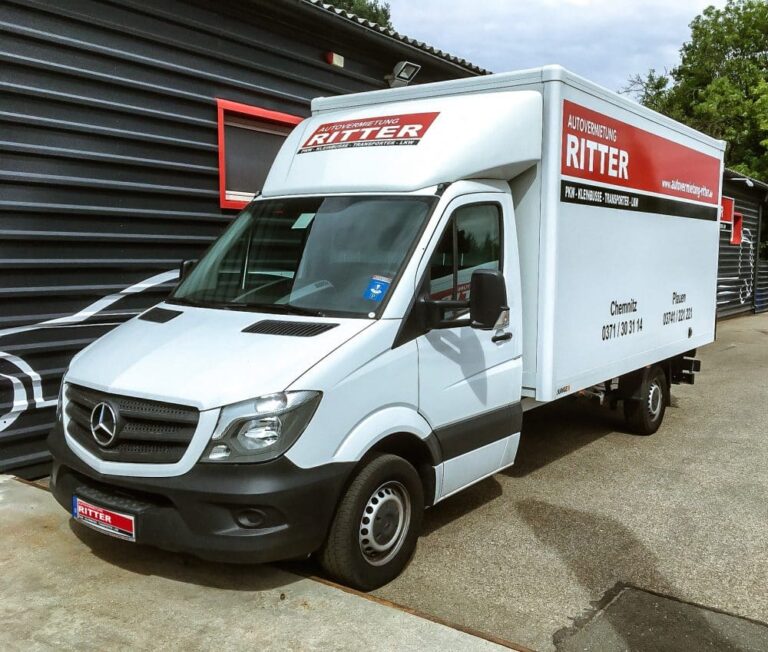 Weißer Mercedes LKW mit Kofferaufbau der Autovermietung Ritter vor einem Firmengebäude.
