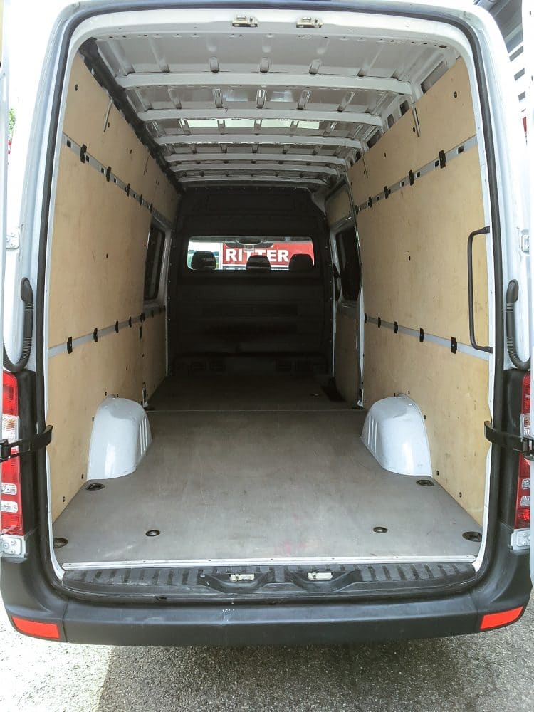 Innenraum eines Mercedes Sprinter mit leerer Ladefläche und Holzverkleidung.