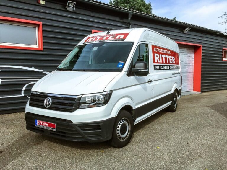 Weißer VW Crafter Transporter der Autovermietung Ritter vor einem Firmengebäude.