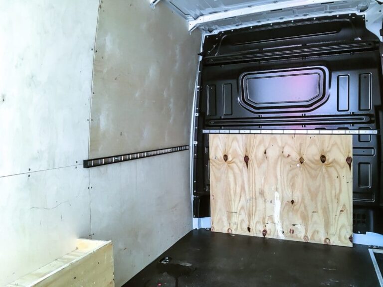 Innenraum eines VW Crafter Transporters mit leerer Ladefläche und Holzverkleidung.