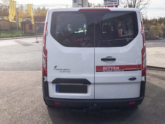 Heckansicht eines weißen Ford Transit Kleinbusses der Autovermietung Ritter.