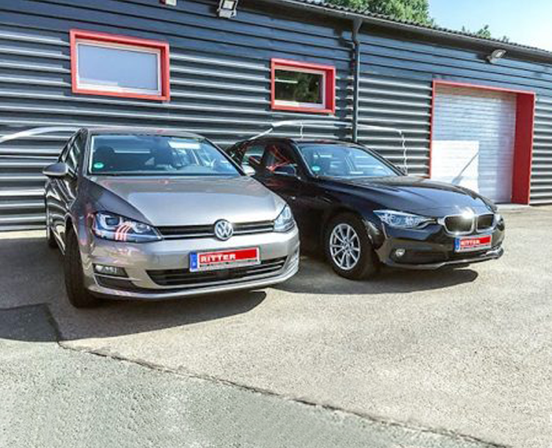 Zwei PKW der Autovermietung Ritter stehen vor einem Firmengebäude.