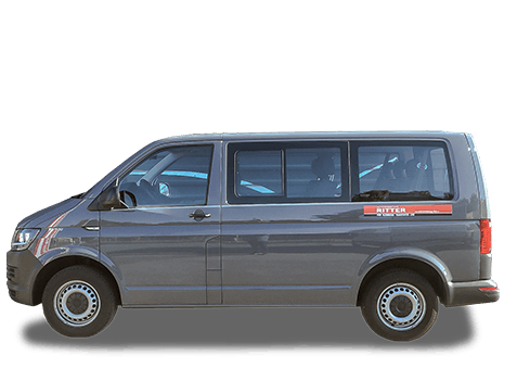 Grauer VW T6 Kleinbus der Autovermietung Ritter vor einem Firmengebäude.