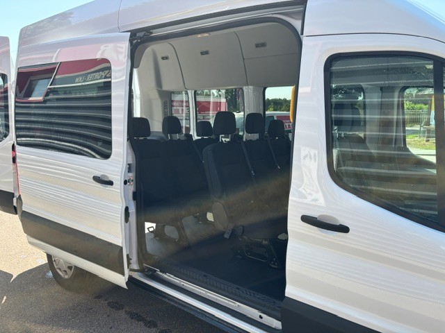 Weißer Kleinbus mit langem Radstand und geöffneter Schiebetür.