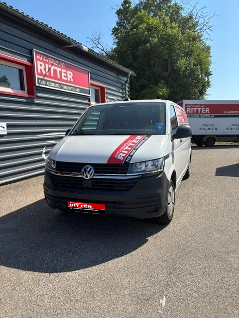 Weißer VW Transporter der Autovermietung Ritter vor dem Firmengebäude.