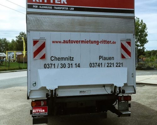 Heckansicht eines weißen LKW der Autovermietung Ritter mit Standortinfos für Chemnitz und Plauen.