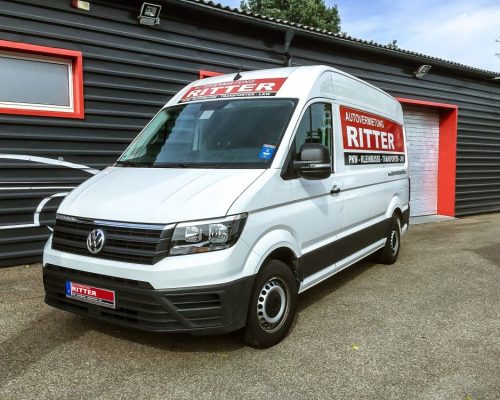 Weißer VW Crafter Transporter der Autovermietung Ritter vor einem Firmengebäude.
