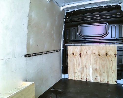Innenraum eines VW Crafter Transporters mit leerer Ladefläche und Holzverkleidung.