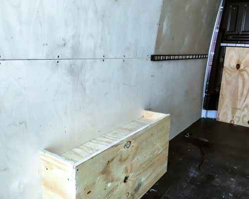 Innenraum eines VW Crafter Transporters mit Holzverkleidung und leerer Ladefläche.