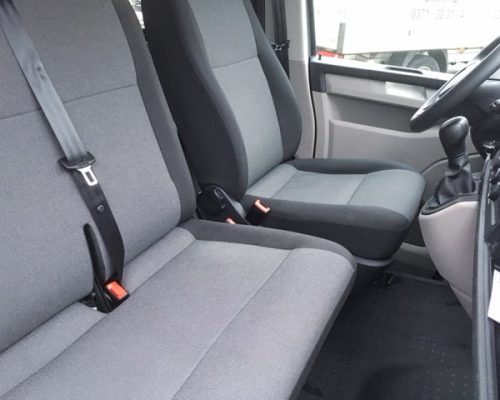Sitzbereich eines VW T6 Kleinbusses mit grauen Sitzen und Sicherheitsgurten.