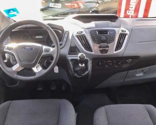 Cockpit eines Ford Kleinbusses mit Lenkrad, Armaturenbrett und Schaltknauf.