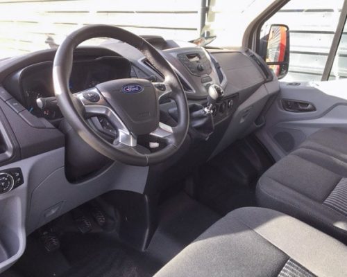 Cockpit eines Ford Transporters mit Lenkrad, Armaturenbrett und Sitzbank.